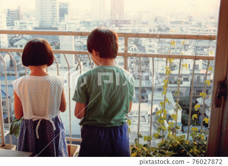 Old film photo: The back view of a sibling staring at the morning glory on the balcony Old film photo: The back view of a sibling staring at the morning glory on the balcony 76027872