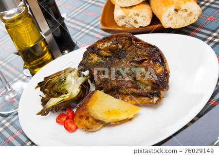 Spanish dish - lamb head with artichoke, tomatoes and potatoes 76029149