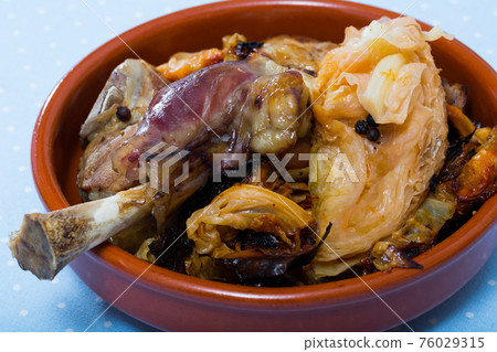 Fried tasty lamb with cabbage prepared and served at clay bowl 76029315