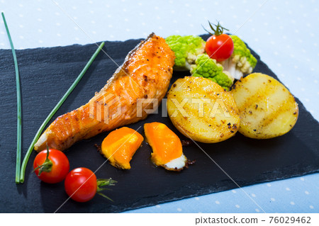 Grilled salmon with egg yolk and vegetables Grilled salmon with egg yolk and vegetables 76029462