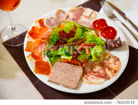 Catalan salad from greens and vegetables with various meat products 76029539