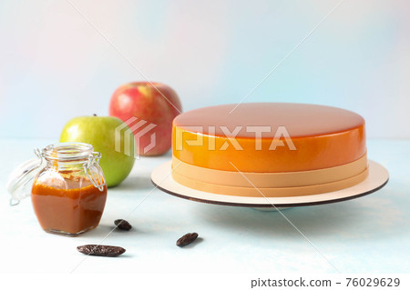 Mousse cake and its ingredients -caramel, green apple, red apple and tonka beans on the table Mousse cake and its ingredients -caramel, green apple, red apple and tonka beans on the table 76029629