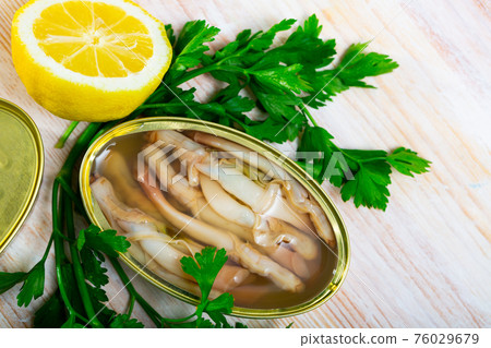 Tasty natural navajas in open tin can served with greens and lemon Tasty natural navajas in open tin can served with greens and lemon 76029679