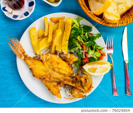 Roasted lionfish with potatoes and fresh greens Roasted lionfish with potatoes and fresh greens 76029804
