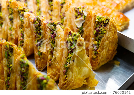 Sweet baklava with honey and nuts on showcase in Turkish confectionery 76030141