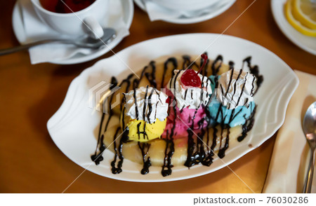 Ice cream based banana split with whipped cream and chocolate sauce Ice cream based banana split with whipped cream and chocolate sauce 76030286