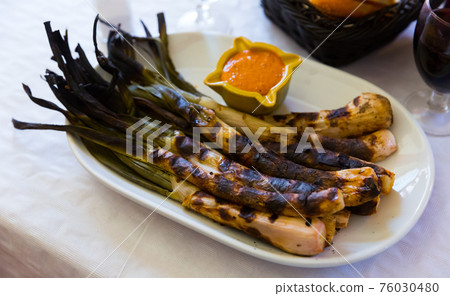 Grilled calcots with romesco sauce Grilled calcots with romesco sauce 76030480