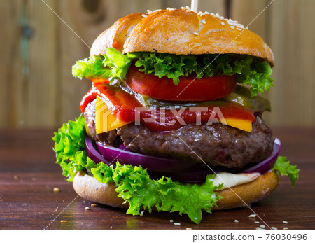 Hamburger with beef and ketchup, tomato, cheese, cucumber and lettuce Hamburger with beef and ketchup, tomato, cheese, cucumber and lettuce 76030496