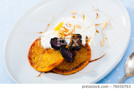 Dessert with caramelized oranges, yogurt, brambleberries Dessert with caramelized oranges, yogurt, brambleberries 76030763