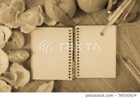 Empty notebook pages and tangerines 76030924