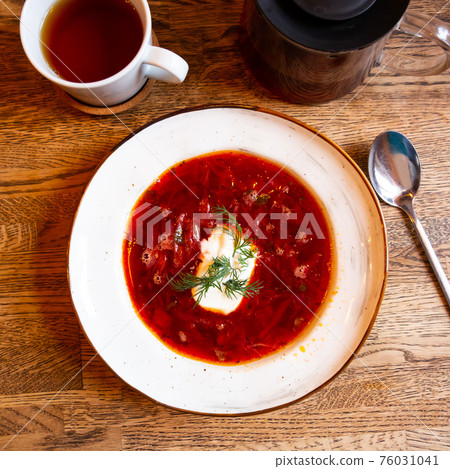 Plate of red borscht garnished with dill and smetana Plate of red borscht garnished with dill and smetana 76031041