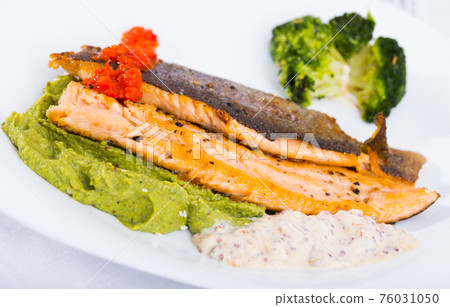 Tasty steak of fried river trout fillet with broccoli and sause tartar on plate 76031050