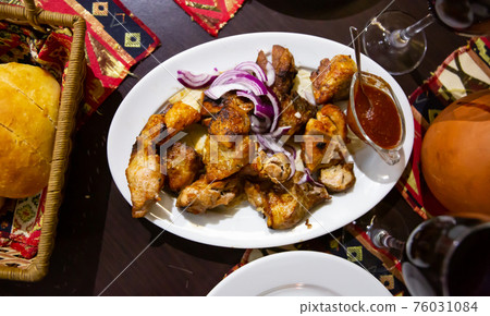 Appetizing pork shish kebab of Georgian cuisine with adzhika and onion Appetizing pork shish kebab of Georgian cuisine with adzhika and onion 76031084