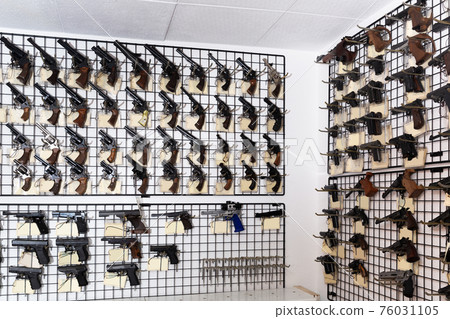 Gun shop interior with handguns displayed on rack Gun shop interior with handguns displayed on rack 76031105