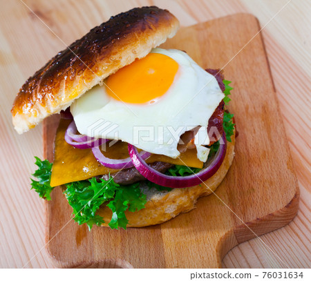 Hamburger with fried egg, bacon, cheese, lettuce, onion 76031634