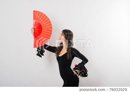 Portrait of beautiful young woman dancing flamenco in studio 76032029