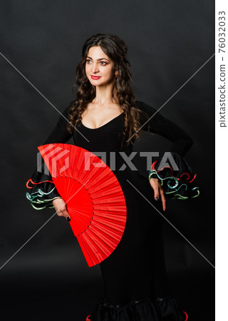 Portrait of beautiful young woman dancing flamenco in studio 76032033