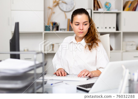 Portrait of young female office worker 76032288