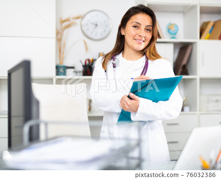 Young female therapist fills out an appointment form on a tablet in the office 76032386