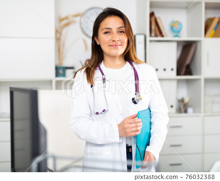 Female therapist stands with a folder of documents in the office 76032388