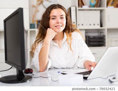 Portrait of young female office worker 76032421