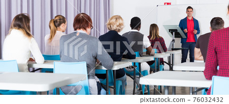 Students with teacher studying in classroom 76032432