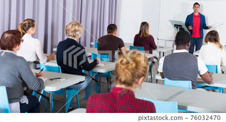 Students working with professor in auditorium 76032470