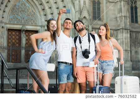 Four ordinary travellers making selfie 76032582