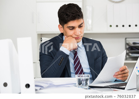 Adult businessman is reading documents about the transaction 76032837