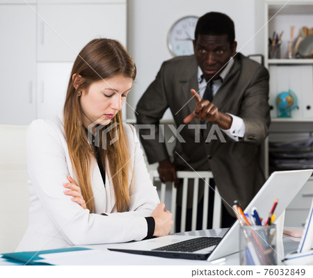 Angry male boss screaming to young female manager during working 76032849