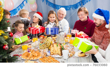 Family exchanging Christmas gifts 76033060