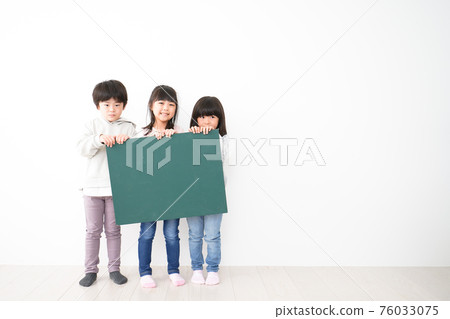 Children holding a blackboard together 76033075