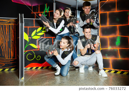 Happy people posing with laser guns 76033272