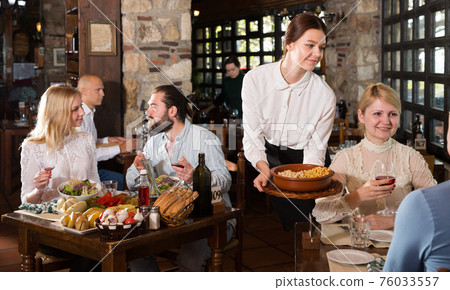 Waitress bringing dishes to guests Waitress bringing dishes to guests 76033557