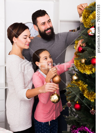 Family decorating Christmas tree Family decorating Christmas tree 76033585