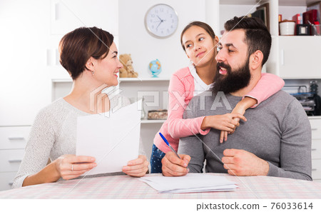 Parents signing property papers 76033614