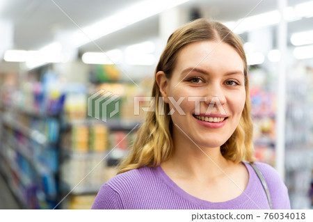 Woman is standing glad after shopping in modern supermarket Woman is standing glad after shopping in modern supermarket 76034018