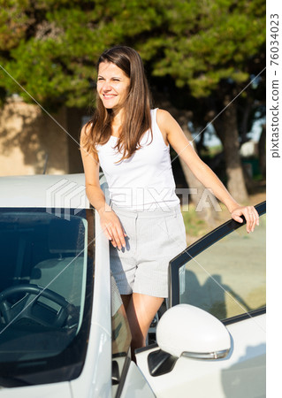 Portrait of driver caucasian woman next to car Portrait of driver caucasian woman next to car 76034023