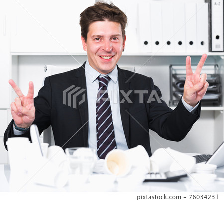 Male worker having glad in the office Male worker having glad in the office 76034231
