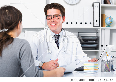 Doctor speaking with client in the medical center 76034232