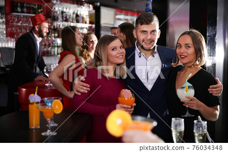 Man and two women at nightclub 76034348