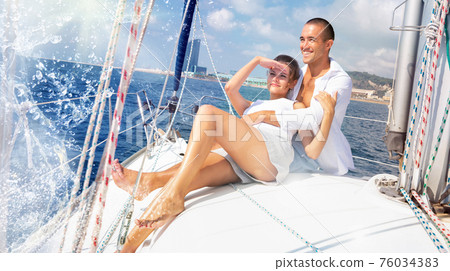 Couple enjoying sea trip along coast of Barcelona Couple enjoying sea trip along coast of Barcelona 76034383