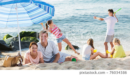 Big family resting on beach Big family resting on beach 76034386