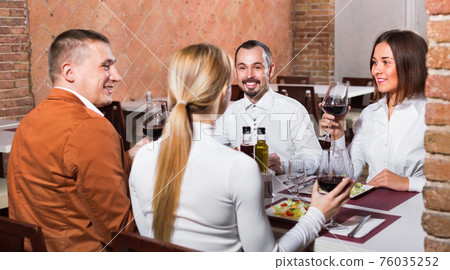 Group of people dining out merrily in country restaurant 76035252