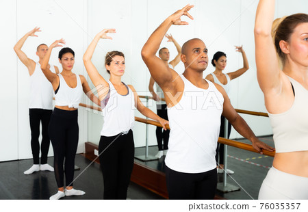 Ballet dancers stands near the ballet barre at ballet hall. Ballet dancers stands near the ballet barre at ballet hall. 76035357