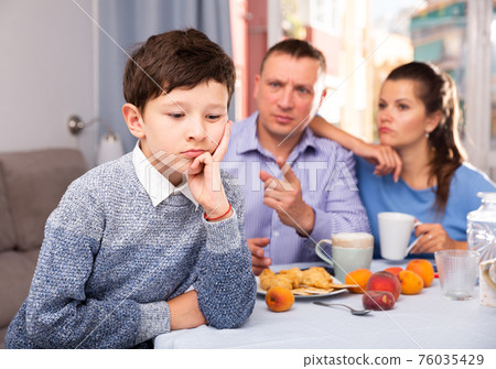 Offended tweenager listening to reprimanding from parents Offended tweenager listening to reprimanding from parents 76035429