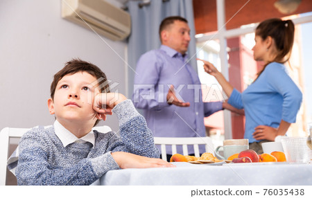 Unhappy boy with quarreling parents 76035438