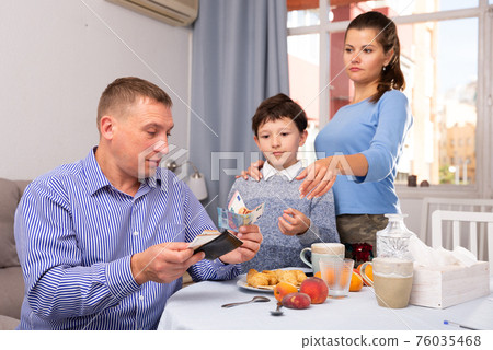 Upset father giving money to wife and son 76035468