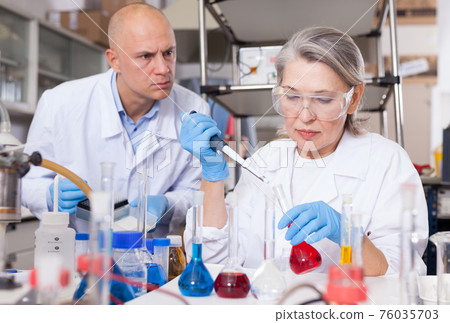 Chemists mixing reagents Chemists mixing reagents 76035703