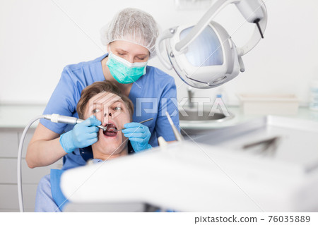 Young man on dental checkup in modern dentist office 76035889